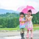 楽しそうに１つの傘に入る二人の子供
