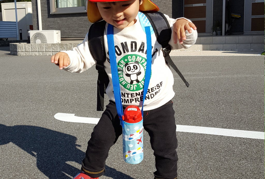 首から水筒をぶらさげた保育園児の男の子