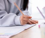小学生が鉛筆を持って宿題をしている風景