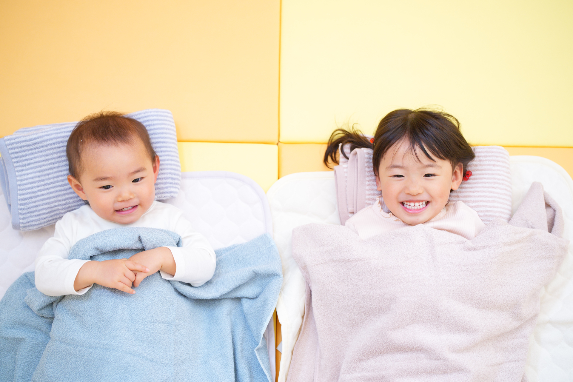 保育園で、なかよくお昼寝をする男の子と女の子
