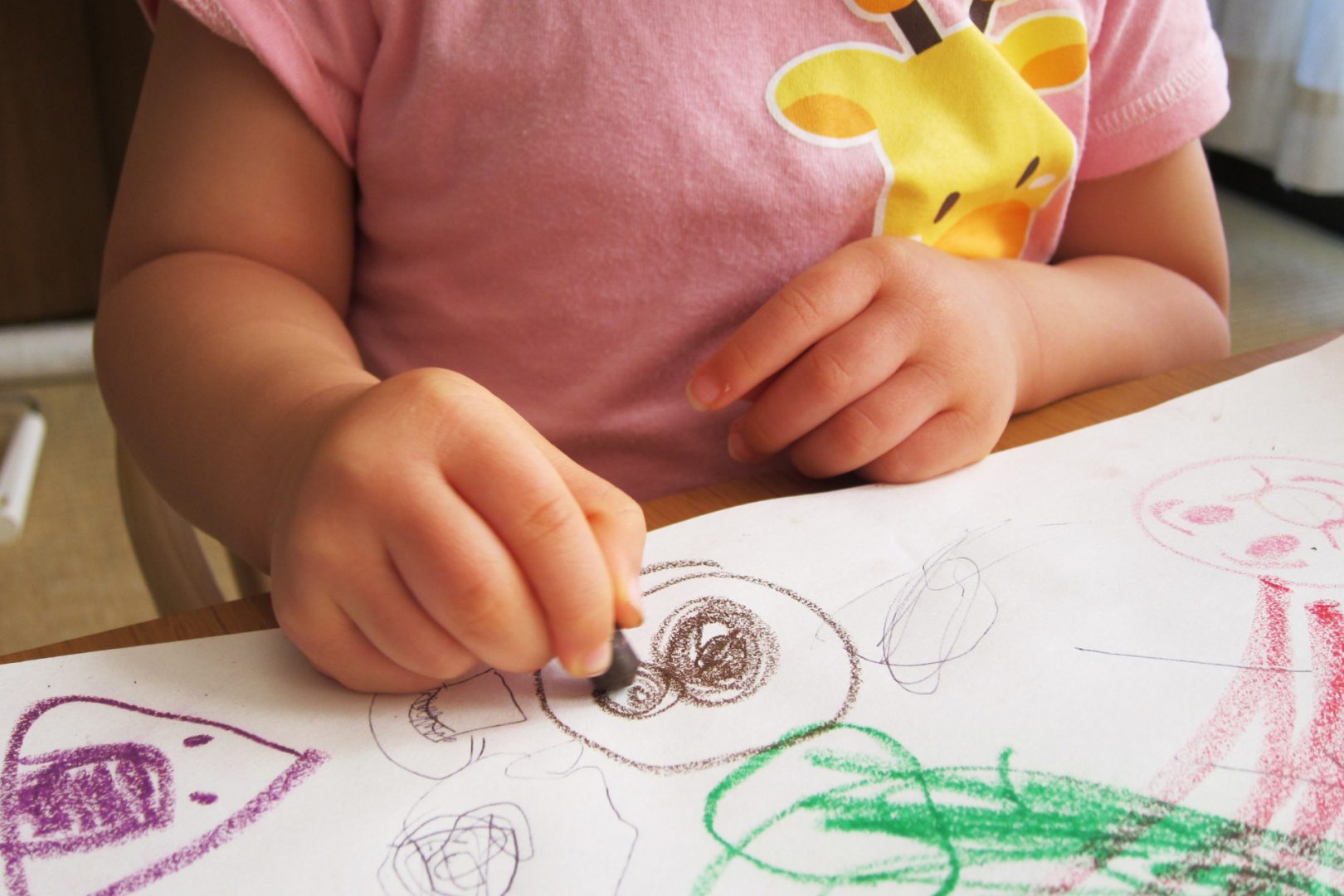 クレヨンでお絵かきをする子ども