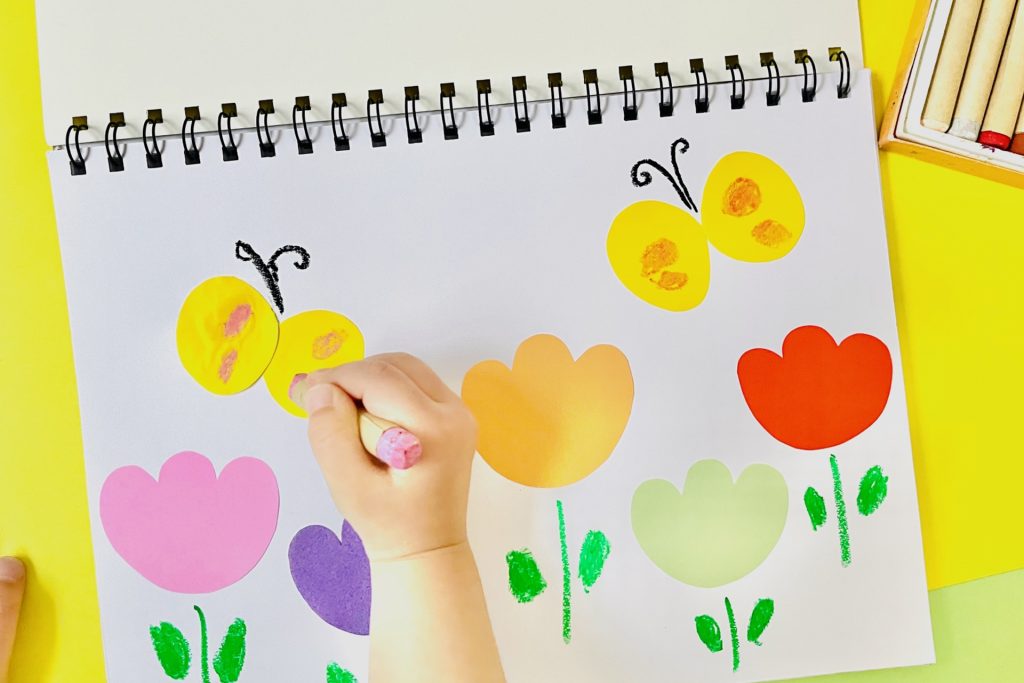 クレヨンで絵を描く子どもの手